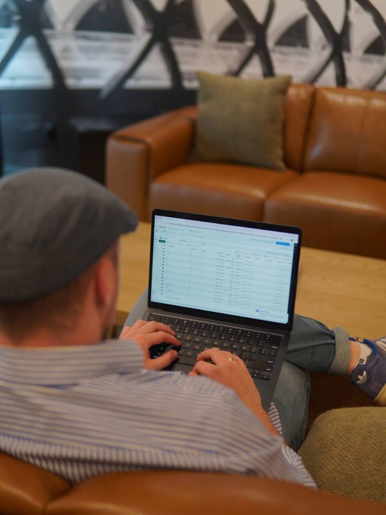 Boostera Digital Inc. — professional working with data and campaigns on a laptop in a modern office